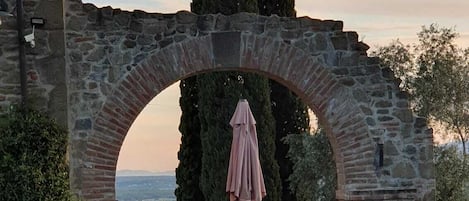 An arched stone structure with a view of the city in the background.