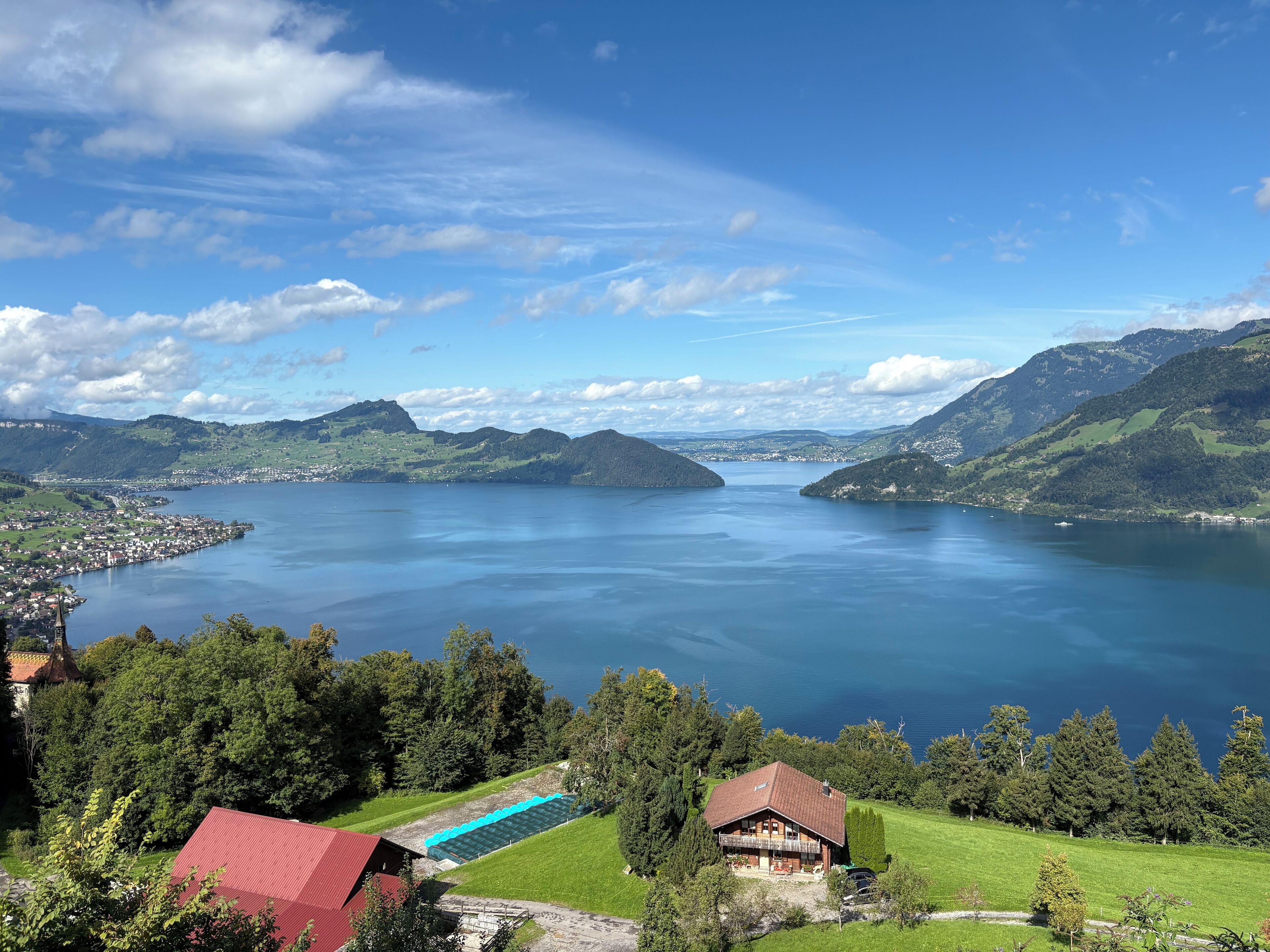 Ein Anwesen am See mit einem großen Haus, einem Schwimmbad und umgebender Bepflanzung.