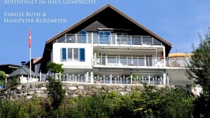 Ein zweistöckiges Haus mit Balkon und einer Flagge.