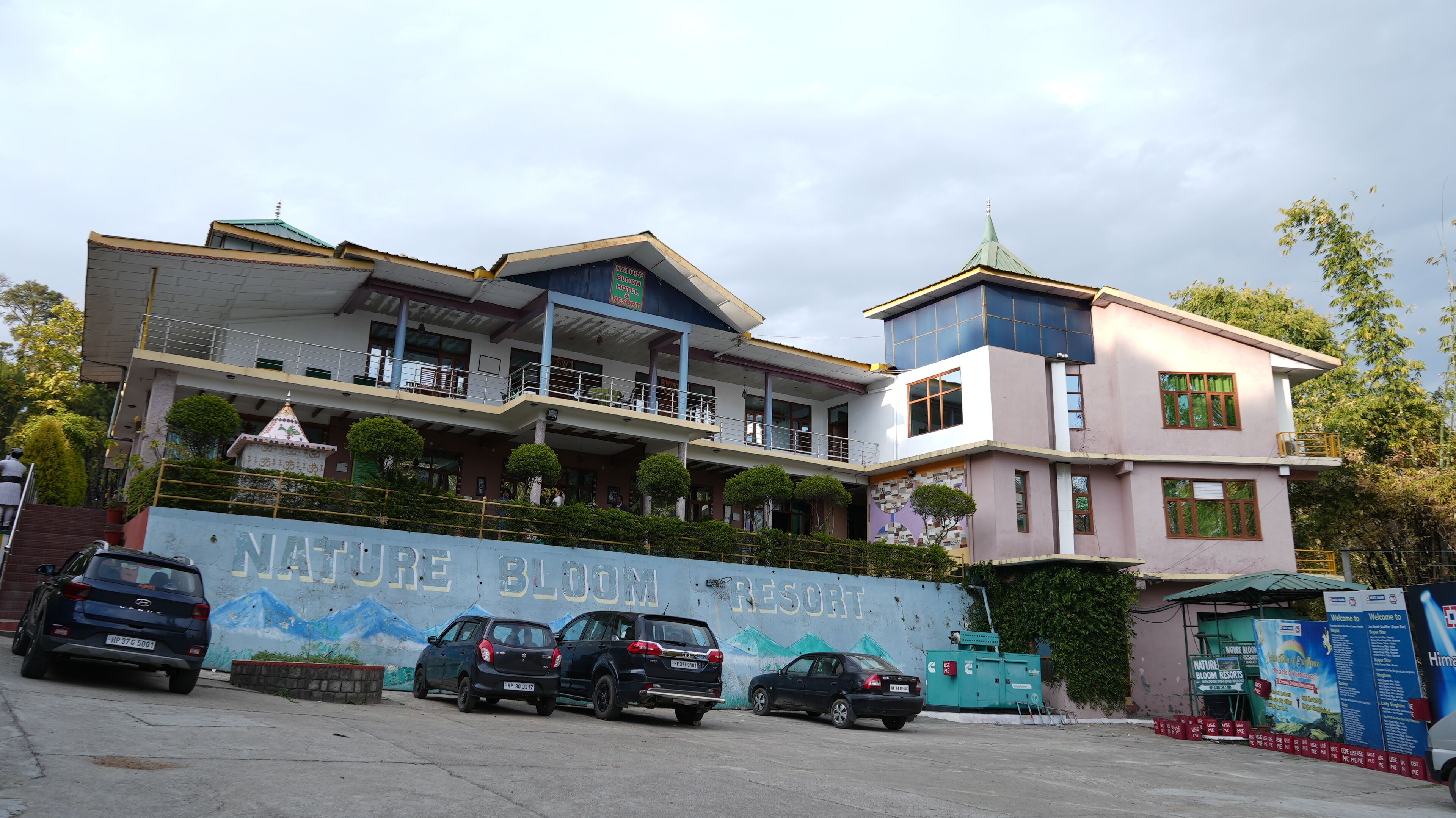 Um hotel de vários andares com uma placa chamativa para o Nature Bloom Resort.