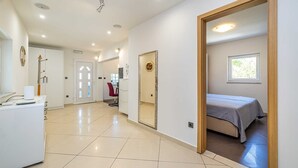 A spacious room with a bed, a desk, and a chair. - Holiday house MICHAEL with shared pool and private jacuzzi (Pinezići)