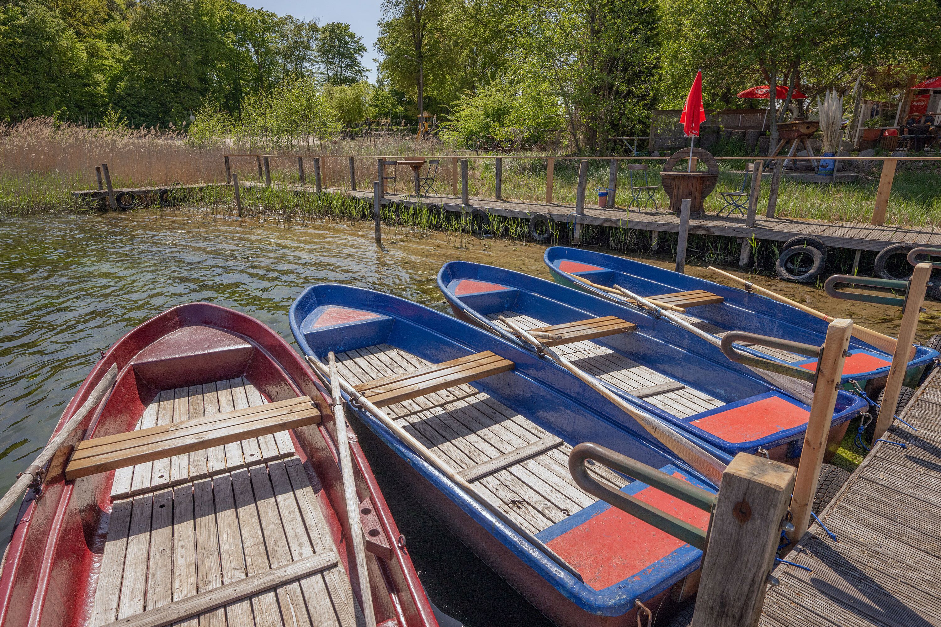 Une rangée de petites barques en bois était amarrée à un quai en bois.