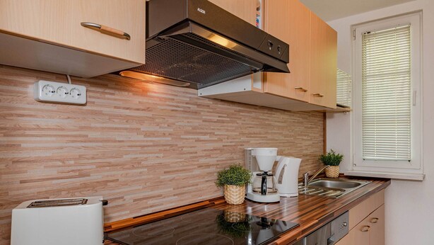 Una cocina moderna con estufa integrada, cafetera y tostadora.