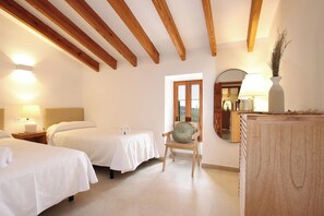 A hotel room with two beds, a wooden chair, a table, a lamp, and a mirror. - Finca Lourdes, quiet location, pool, air conditioning, 5 bedrooms, 5 bathrooms (Pollença)