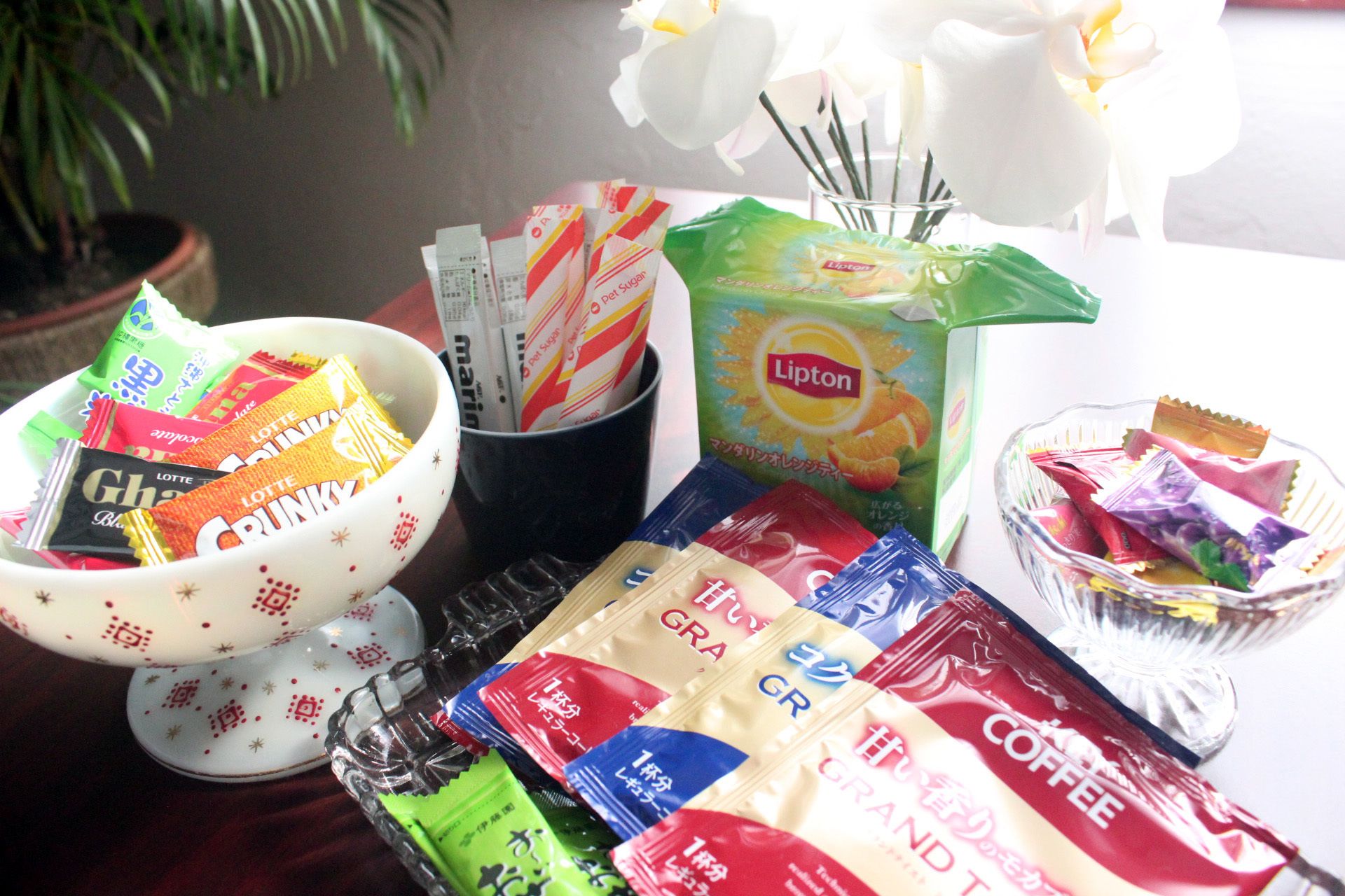 A table with various food items including snacks, a Lipton tea bag, and a coffee packet.