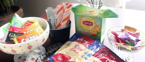 A table with various food items including snacks, a Lipton tea bag, and a coffee packet.
