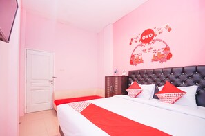 Una camera d'albergo con un letto, un armadio e una parete con un logo rosso.