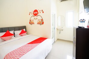 Una camera d'albergo con un letto, un elemento decorativo a parete, un bagno e una televisione.