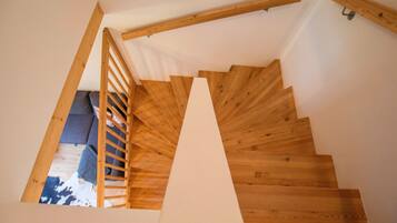 Una escalera de madera con barandilla de madera y una pared blanca.