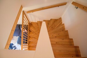 Un escalier en bois avec une rampe en bois et un mur blanc.