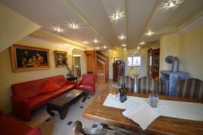 Relax in this inviting living space with a sofa, dining table, and fireplace.