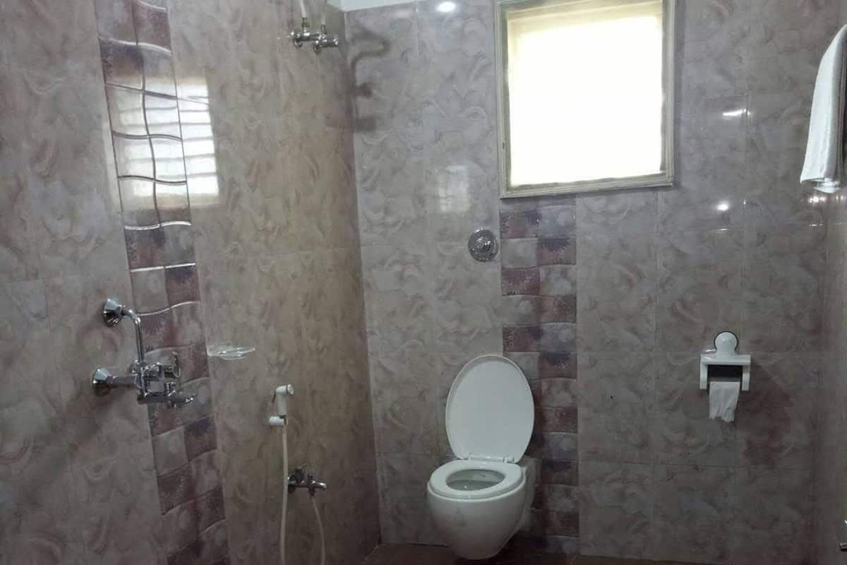 Un baño con inodoro, ducha y ventana.