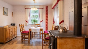 Una cocina acogedora con muebles de madera, una estufa y una mesa de comedor con sillas.