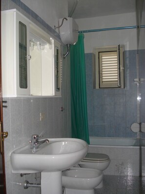 A bathroom with a sink, two toilets, and a shower curtain. - Apartment with sea views, ideal for 6 people, 4 top beaches, shopping on foot (Porto Pozzo G)