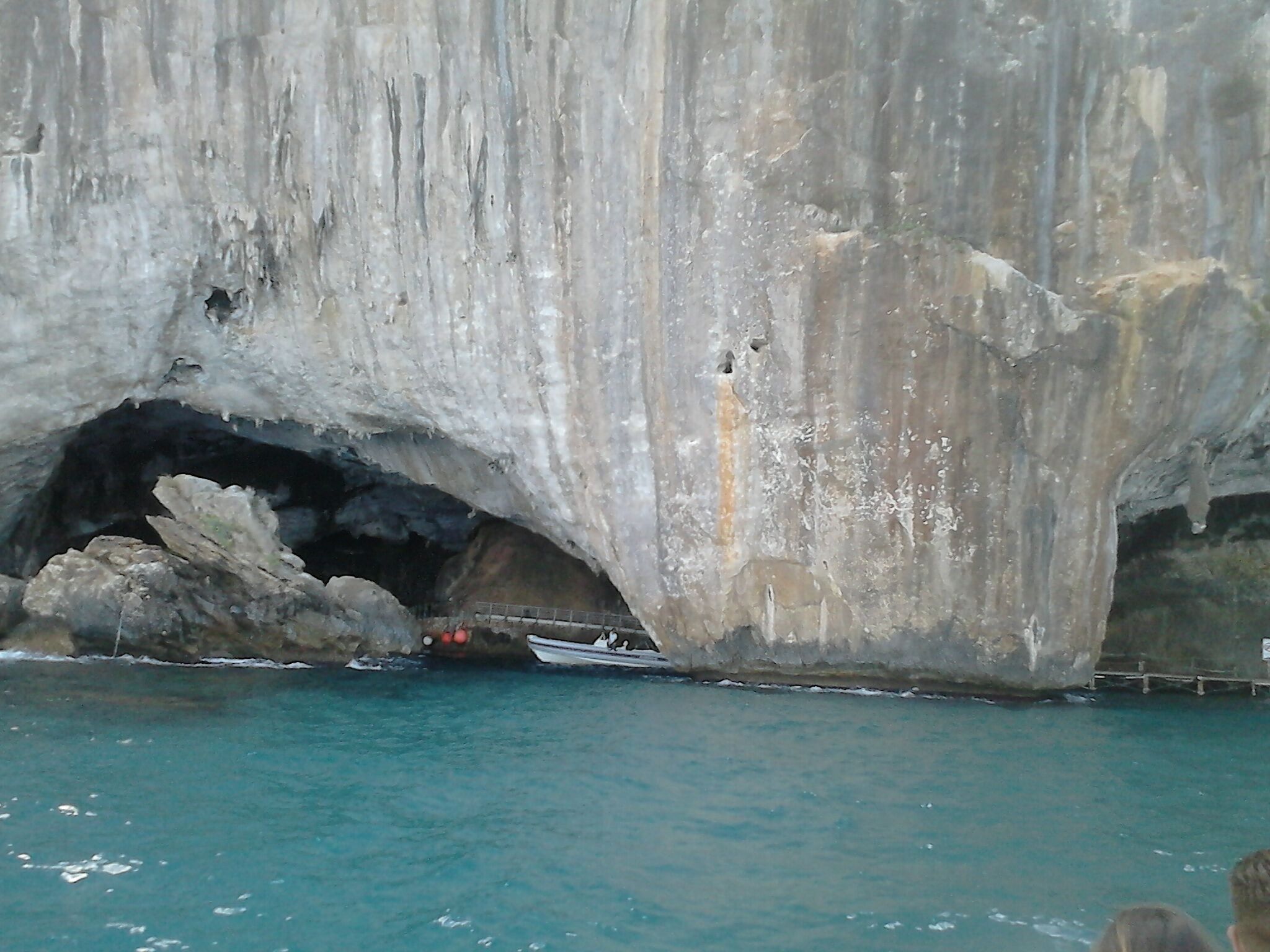 La entrada de una cueva con un bote amarrado en su interior.