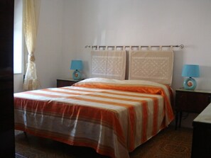 A bedroom with a bed, two nightstands, and a window with curtains. - Apartment with sea views, ideal for 6 people, 4 top beaches, shopping on foot (Porto Pozzo G)
