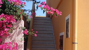 A staircase leading to a building with a textured wall and a window.