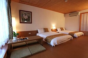 A hotel room with two beds, a desk with a plant, and a wall-mounted air conditioner. - Kanazawa House (Ji'an)