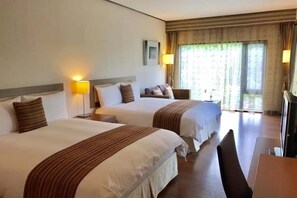 A hotel room with two beds, a desk, and a chair. There are lamps on either side of the beds and a window with curtains. - Kanazawa House (Ji'an)