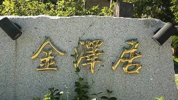 Un letrero de piedra con letras doradas, probablemente indicando un hotel u otro establecimiento.