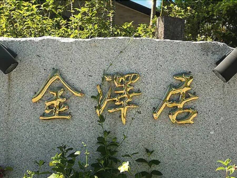 Un letrero de piedra con letras doradas, probablemente indicando un hotel u otro establecimiento.