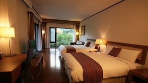 A hotel room with two beds, a desk, a TV, and a view of greenery outside. - Kanazawa House (Ji'an)