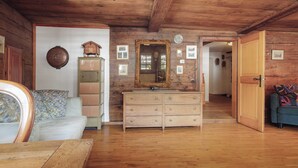 A wooden-paneled room with a large mirror, a dresser, and a sofa.
