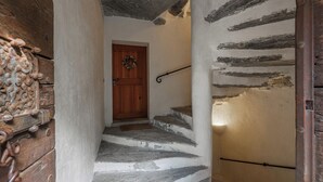 A staircase with stone steps leading to a wooden door with a wreath.