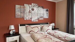 Une chambre d’hôtel bien aménagée, avec un lit, des tables de chevet et une œuvre d’art accrochée au mur.