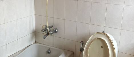 Un baño con bañera, inodoro y ducha.