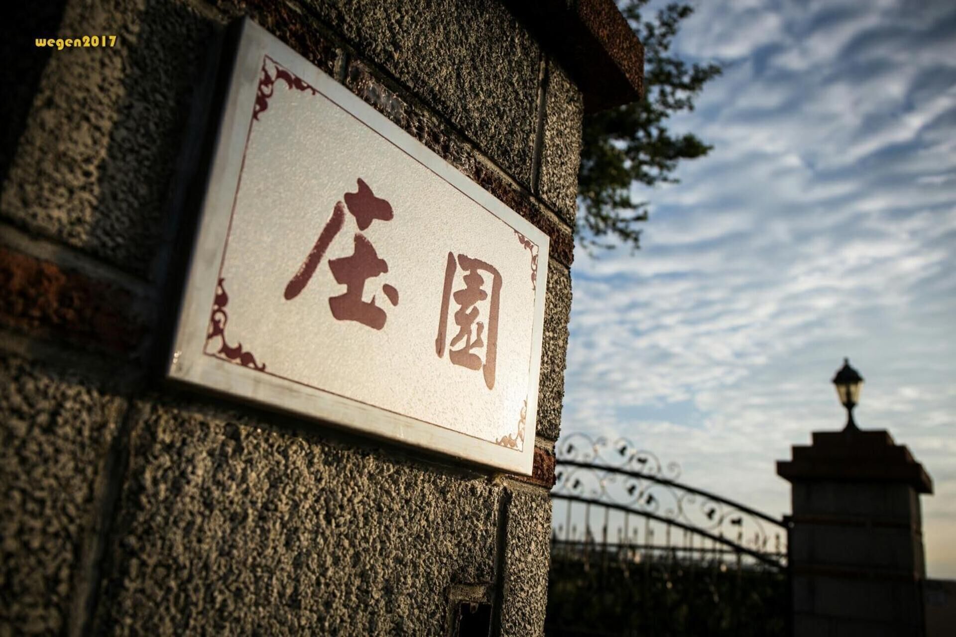 Un muro de piedra con un letrero con caracteres chinos.