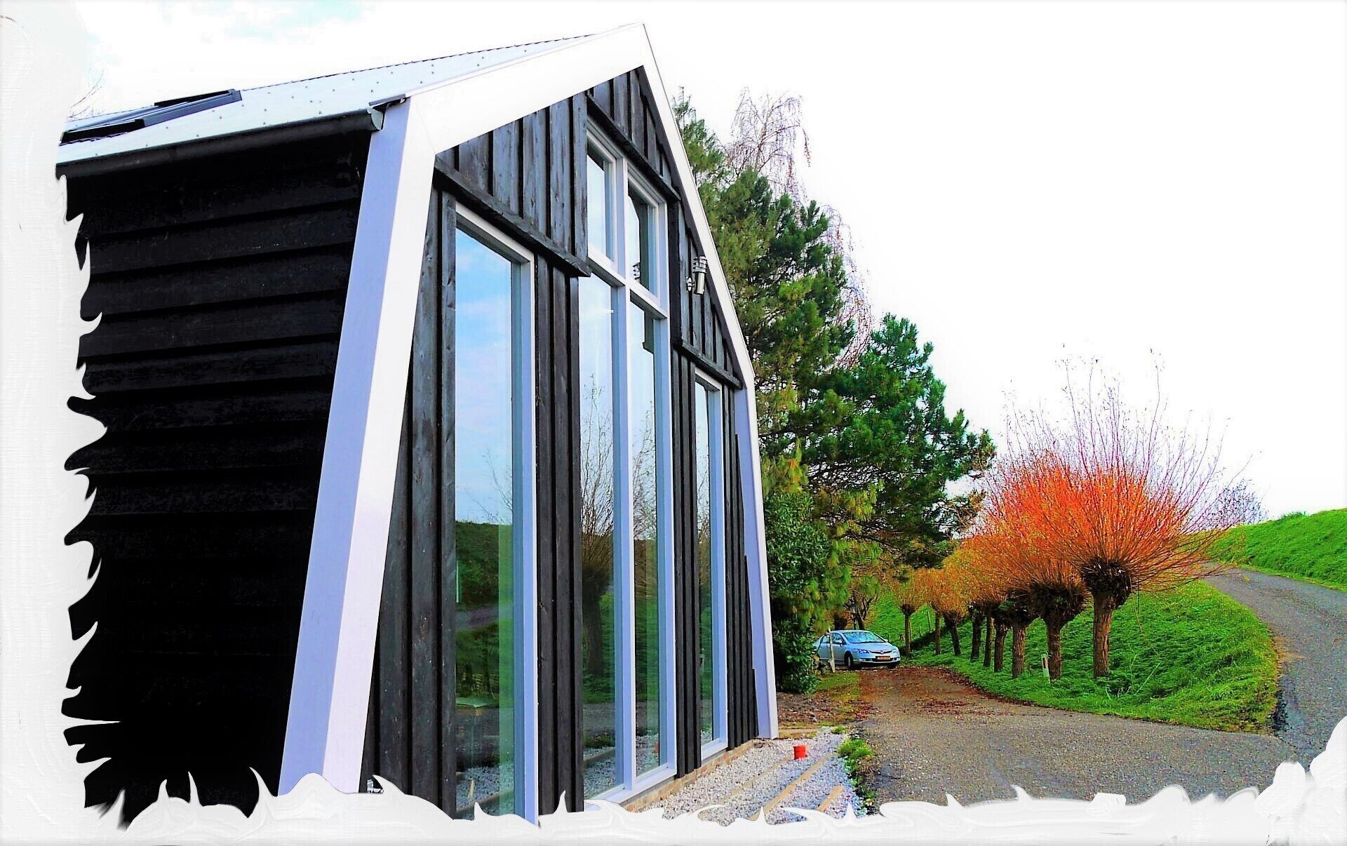 A modern building with large windows and a sloped roof.