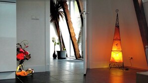 A hallway with a potted plant, a vase with flowers, and a decorative lamp. - “Markermeerlogies am See” Historic, unique, exclusive, and very modern (Bovenkarspel)
