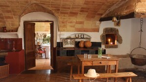 Una cocina rústica con techo de ladrillo, una mesa de madera y una lámpara colgante.