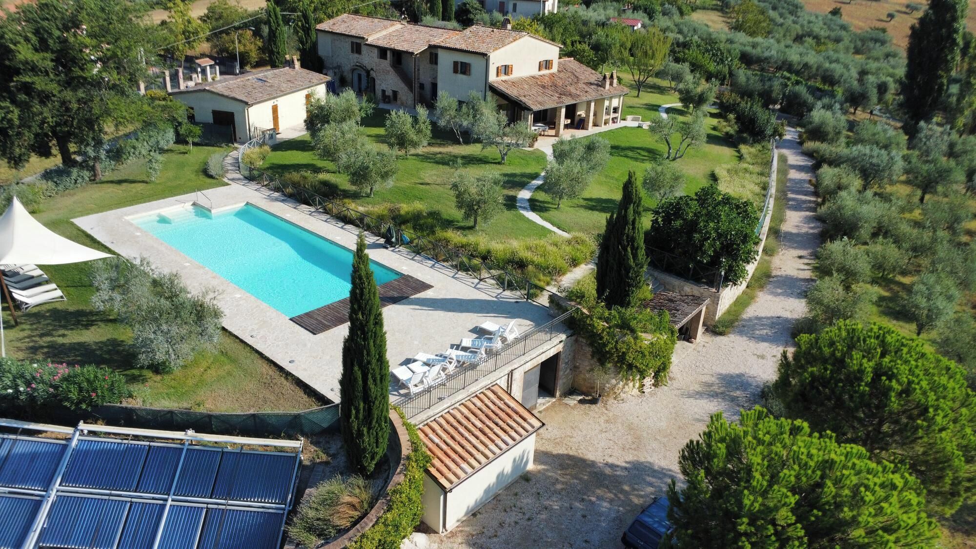A residential property with a swimming pool, solar panels, and a well-maintained garden.