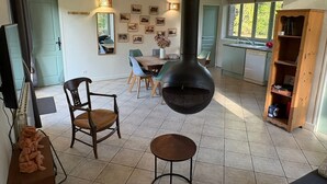 Una cocina con una estufa grande, comedor con sillas y un armario de madera.