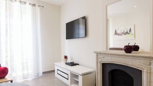 Ein modernes Wohnzimmer mit Kamin, Flachbildfernseher und einem weißen Konsolentisch.