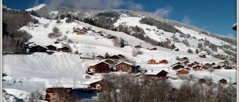 A snow-covered mountain village with wooden cabins.