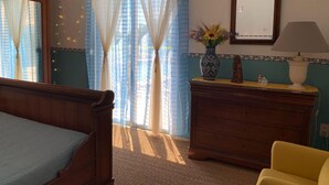 Une chambre à coucher avec un lit en bois, une commode, une lampe et un vase rempli de fleurs.