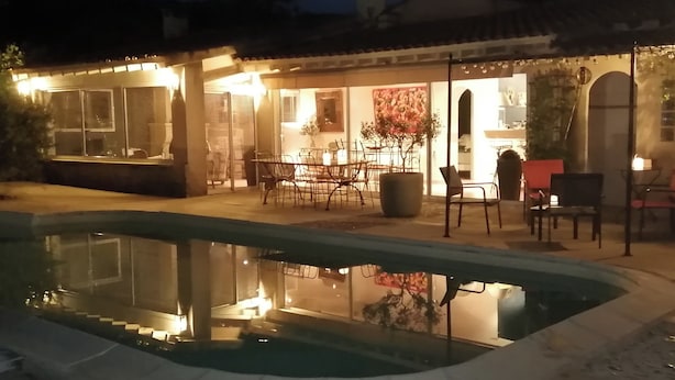 Un espace aménagé au bord de la piscine, avec un coin repas et l’entrée du restaurant.