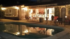 A poolside area with a dining setup and a restaurant entrance. - Mas with swimming pool in countryside, meticulous decoration, very comfortable (Vacqueyras)
