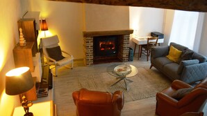 A cozy living room with a fireplace, leather chairs, a sofa, and a dining table. - Renting a house In the heart of Amiens (Amiens)