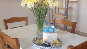 A dining table with a vase of flowers, a menu, and a tray of food items. - Renting a house In the heart of Amiens (Amiens)