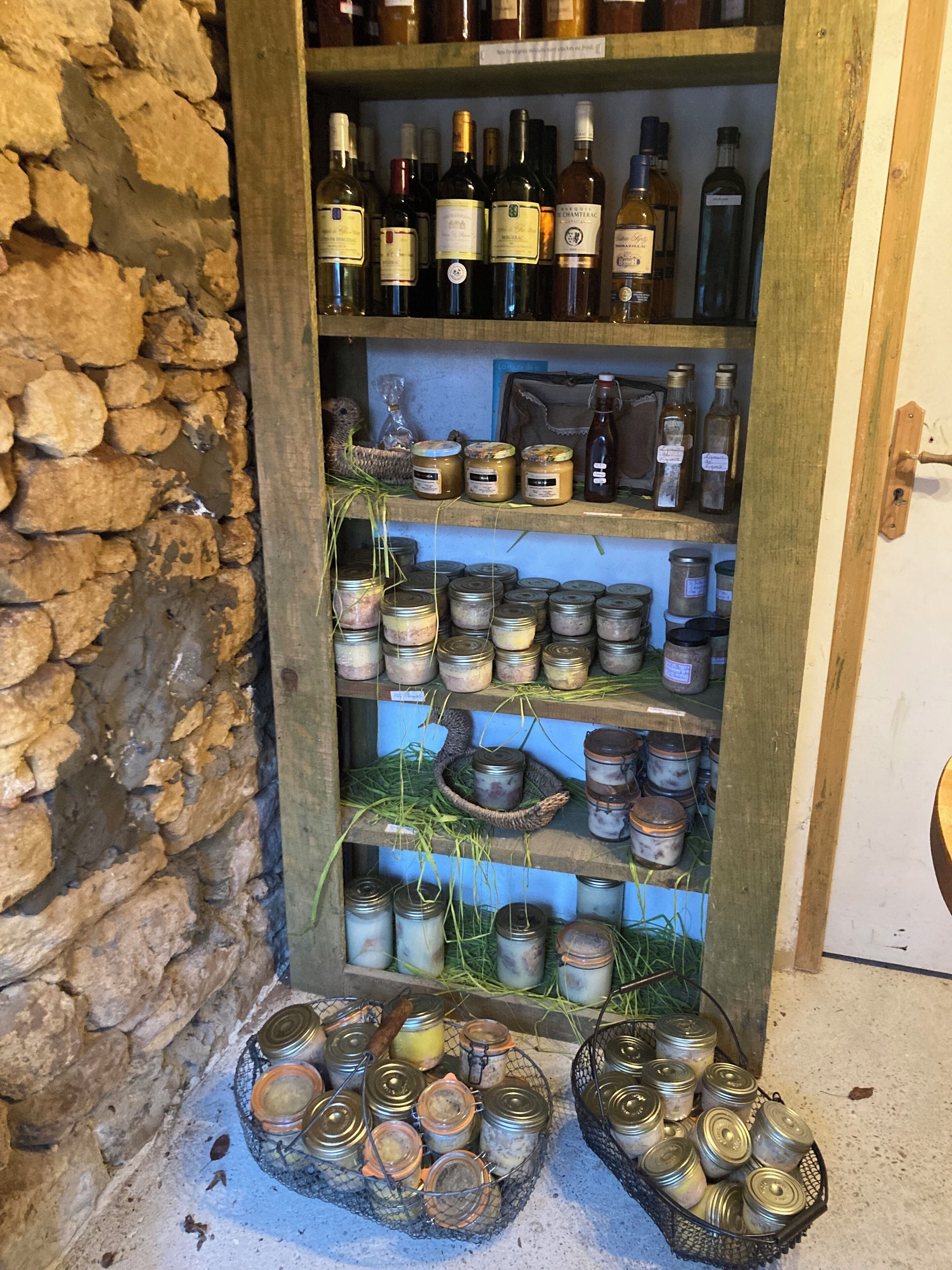 A wooden wine rack with bottles and jars.