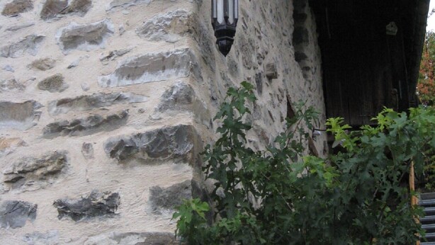 A stone wall with two lanterns and a wooden sign with the word "ATTENTION" repeated.