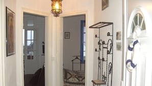 A hallway with a bed, a hanging coat rack, and a door with a life preserver. - Apartment in villa for 6 persons-2**- . Sea view, somme bay.    (Ault)