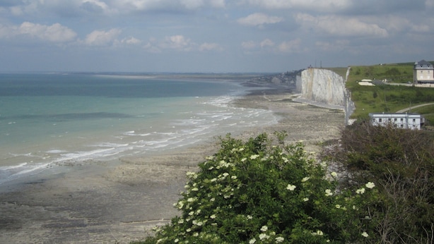 A coastal landscape with cliffs, a beach, and a building on a grassy hill. - Apartment in villa for 6 persons-2**- . Sea view, somme bay.    (Ault)