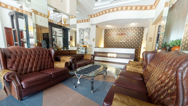 Un hall d’hôtel avec des canapés en cuir, une table basse et un comptoir de réception.