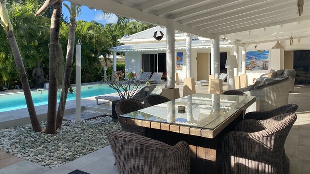 A covered outdoor area with a pool, wicker furniture, and a ceiling fan. - New! Villa Uhaïna, Zen and atypical (SAINT-FRANÇOIS)