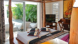 A bedroom with a bed, a desk, a television, and a view of the outdoors. - New! Villa Uhaïna, Zen and atypical (SAINT-FRANÇOIS)